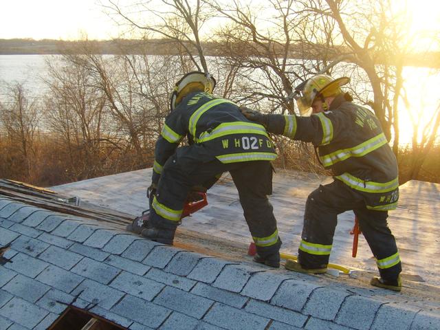 Chief Simmons and Lieutenant Holdredge venting a roof at training.