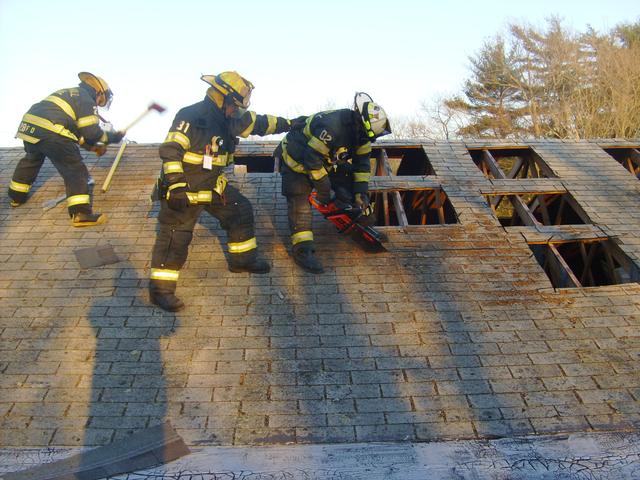 Lieutenants Holdredge and Andaloro assist Chief Simmons during Vent Training at a local aquired structure. 