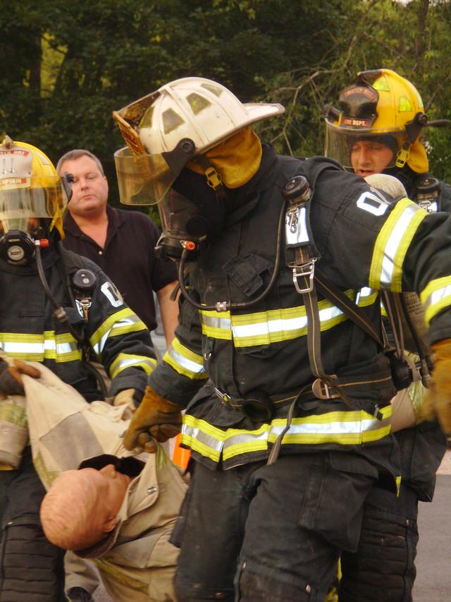 Chief Scott Harold, Captain Jane Perkins, and Firefighter Steve DePerry work on moving a victim at the WHFD annual SCBA course. Dep. Chief Peacock observes in the background. 